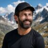 Ritratto di Jeff, coach virtuale per trail running e triathlon, con cappellino nero in ambiente alpino
