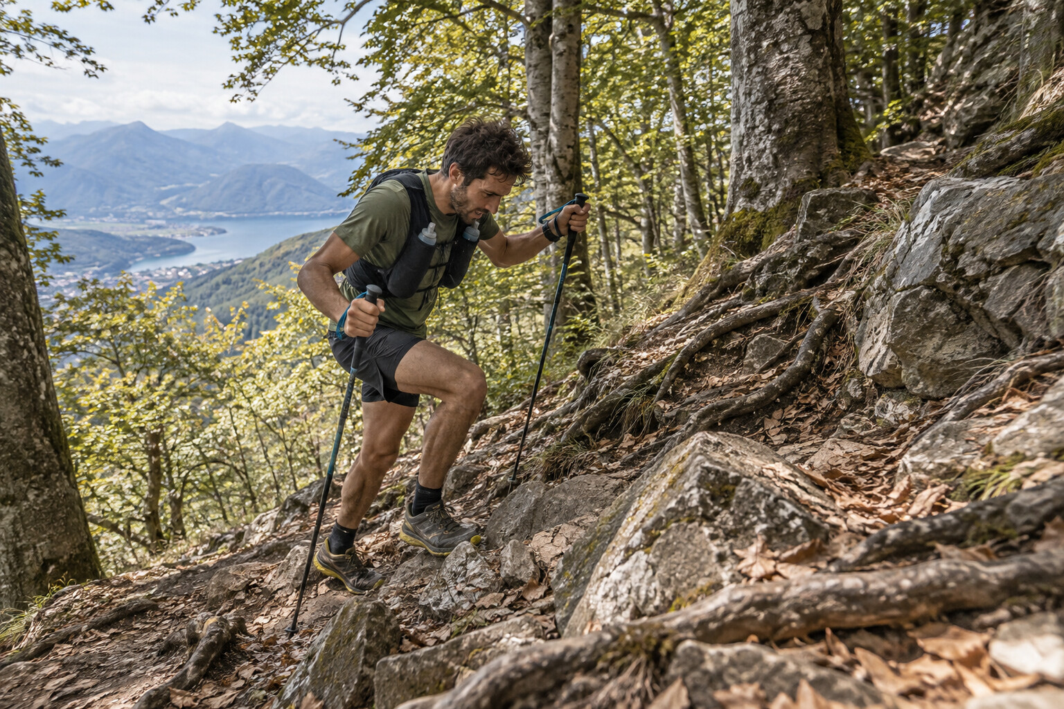 Trail runner affronta una ripida salita rocciosa nel bosco di Miazzina